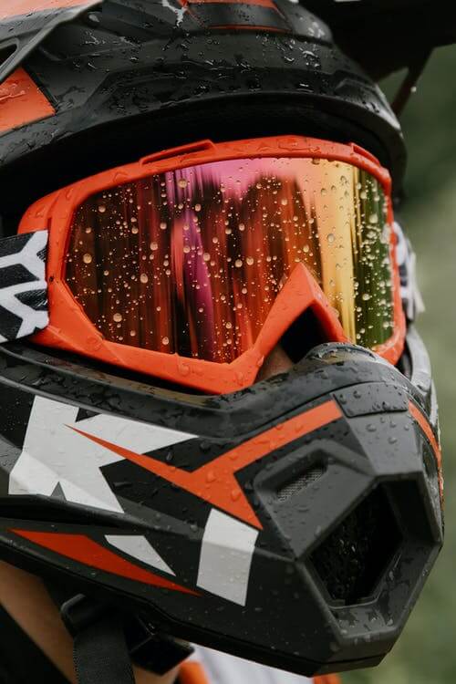 Picture shows orange dirt bike helmet googles up close.